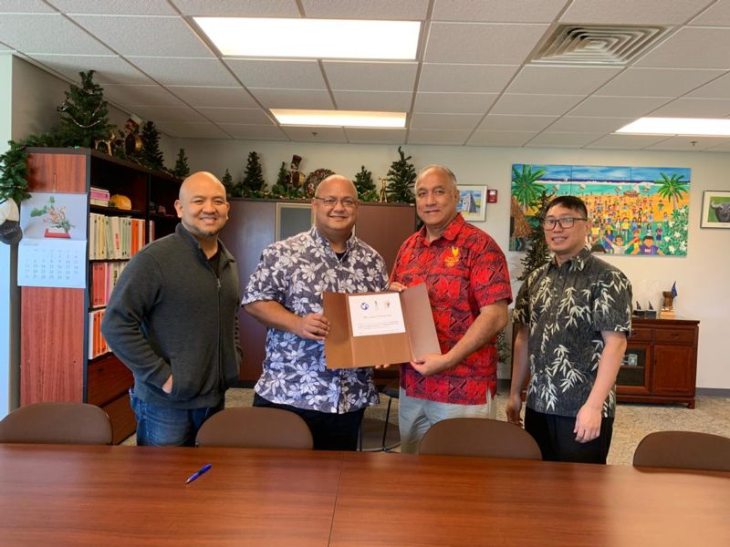 GNOC and GDOE representatives pose with the signed Memorandum of Understanding.